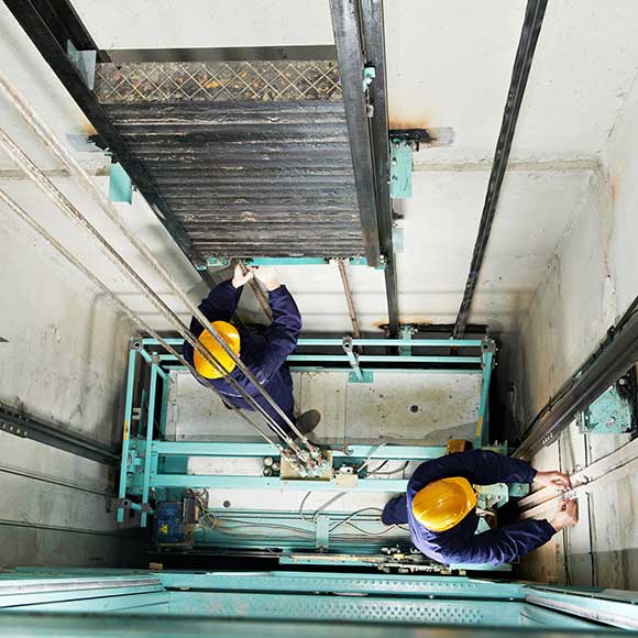 Banner_Products_Specialist-Risks-Contractors_06-Lift-Engineers-1 Two men working on lift to promote Greenfield Risk Solutions Insurance Brokers - Specialist Risk and Contractor Insurance - Lift Engineers